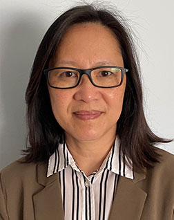 Liani Setyawan wearing glasses and a blazer, portrait on white background, professional headshot.