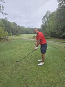 Barry Winebarger prepares to swing a golf club on the course, welcoming him to the MMI Direct Merge-Purge team.